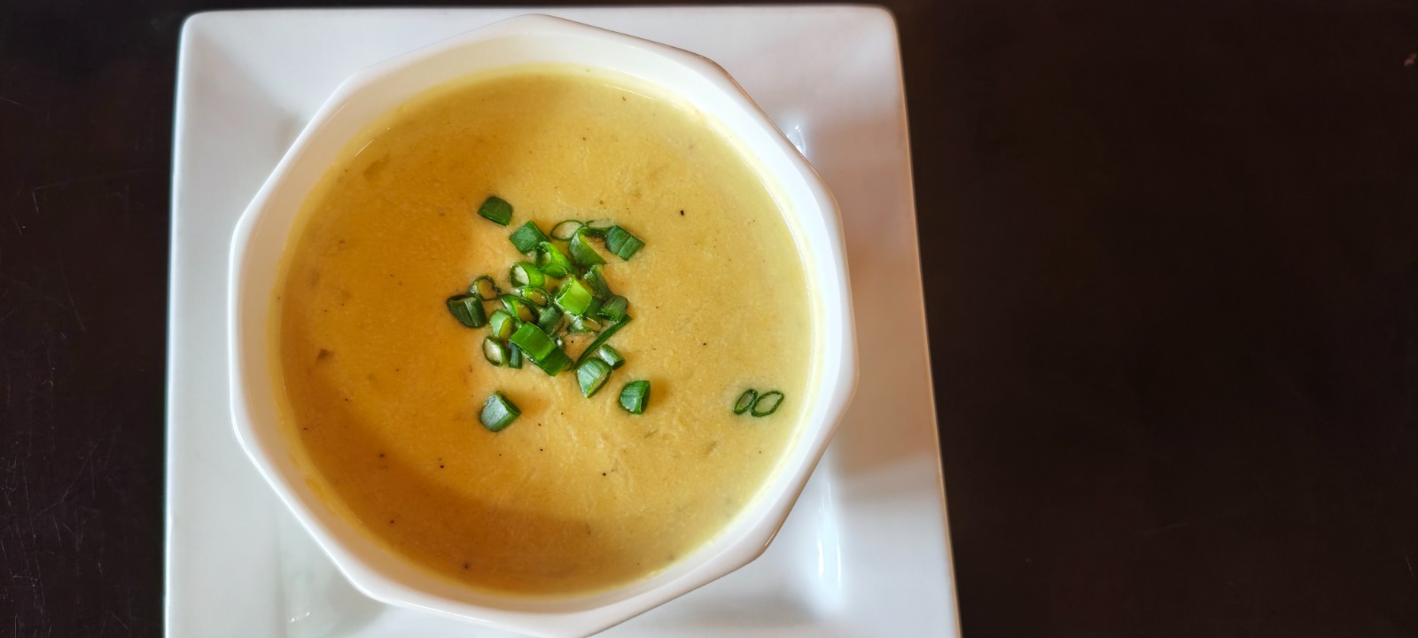 Tazón de sopa de mostaza holandesa con tocino crujiente y cebollín